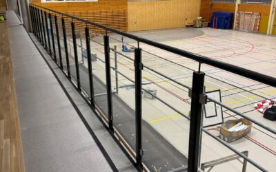Vatnesenteret AS. har ferdigstilt rekkverk i idrettshall. Stolpe glass rekkverk montert på betong kant